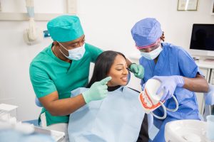 A dentist gives a consultation to a patient and with his assistant they explain the teeth.