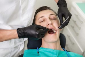 Man Receiving Dental Examination at Dentist Office