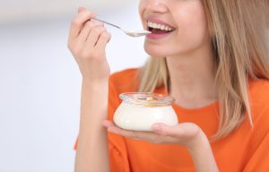 Woman Enjoying Yogurt with Fruit in Bright Light
